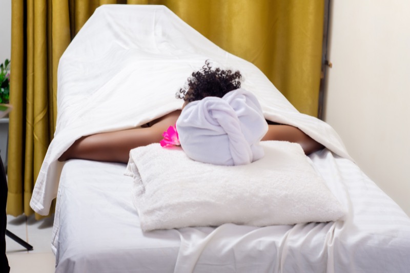 Guest relaxing under towels on a spa treatment bed