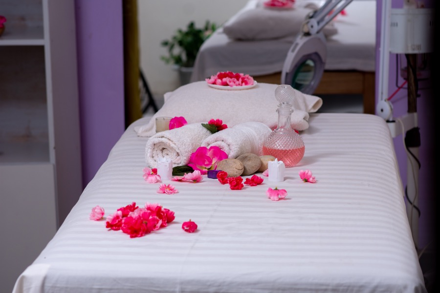 Treatment bed set with warm towels, oil and fresh flowers